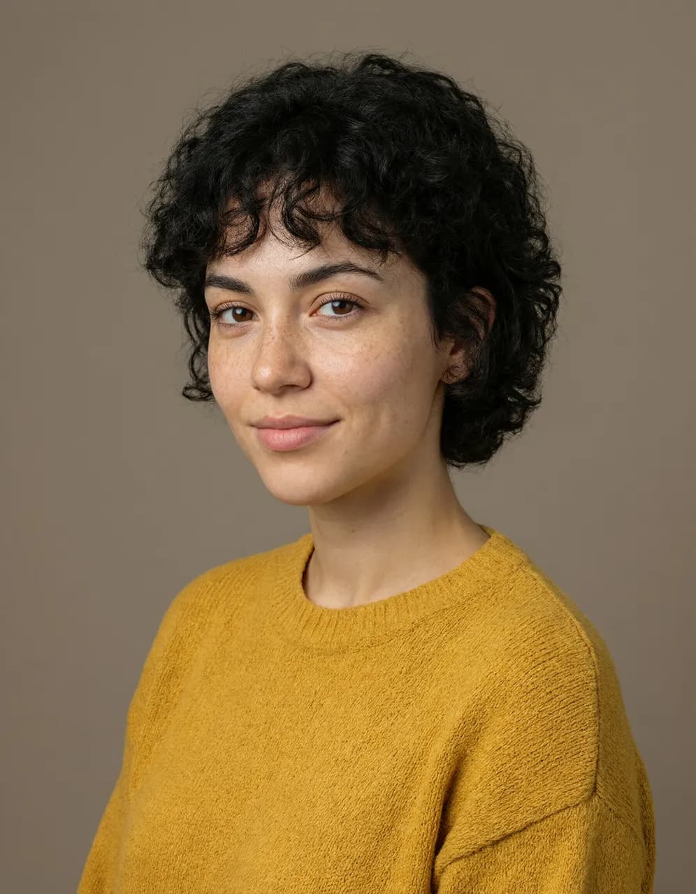 Un ritratto in studio di una donna con un maglione color senape